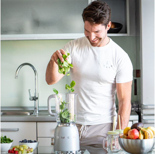 Jan Kovačič preparing fresh food and a green smoothie in the kitchen